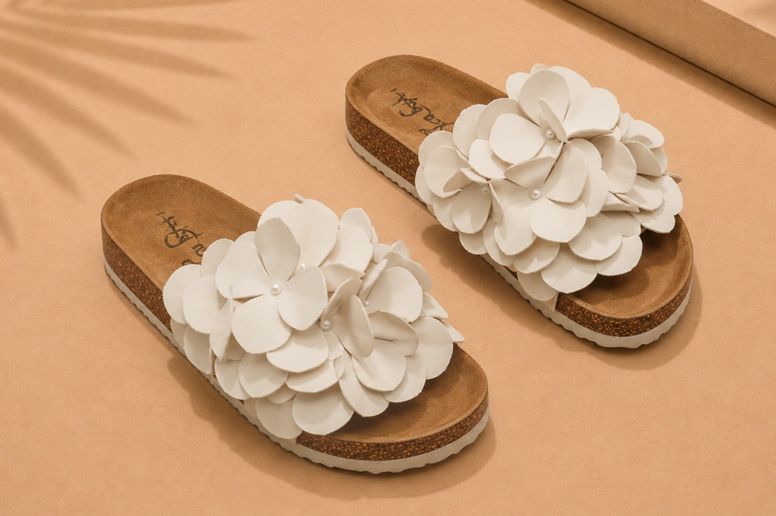Flat sandal with 3D floral appliqué and bow-tie knot detail